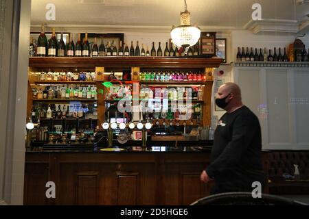 Die Mitarbeiter des Richmond Pub in Liverpool bringen Tische und Stühle ein, in der Nacht bevor neue Maßnahmen in der Region in Kraft treten, nachdem die sechs Bezirke in der Liverpool City Region auf Rang 3, dem höchsten Niveau, Des neuen Coronavirus-Warnsystems der Regierung. Stockfoto