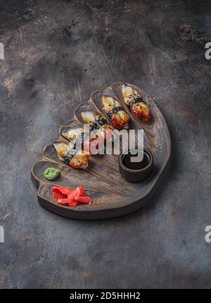 Aal Sushi nigiri Holzbrett auf schwarzem Hintergrund Stockfoto