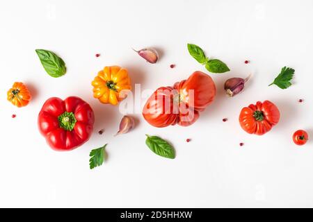 Tomaten, Basilikum, Gewürze, Pfeffer, Knoblauch. Vegane Ernährung. Kreative Komposition isoliert auf weißem Hintergrund. Frisches Gemüse Kochkonzept, Draufsicht Stockfoto