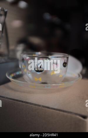 Vertikale Nahaufnahme einer niedlichen Teetasse und einer Untertasse Mit einer schwarzen Katze aufgedruckt Stockfoto