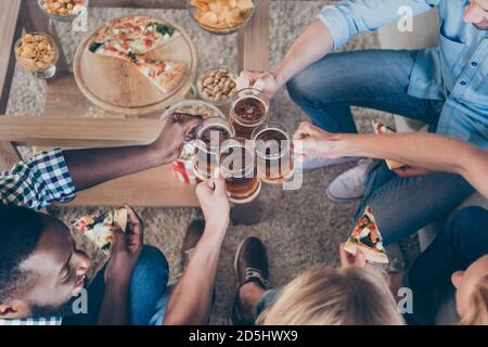 Oben über dem hohen Winkel abgeschnitten Foto von positiven besten Kameraden Mann sitzen Couch haben Urlaub Toast Prost clink Bier Getränk Tasse essen Pizza Fast Food in Stockfoto