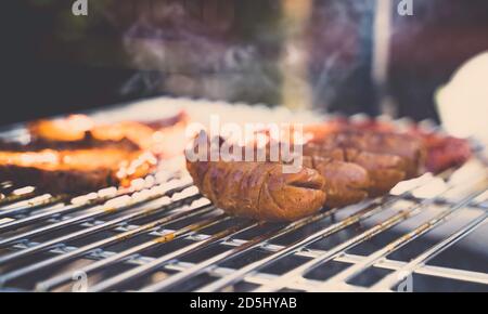 Würstchen auf dem Grill. Grill im Garten. Rauch im Hintergrund. Stockfoto