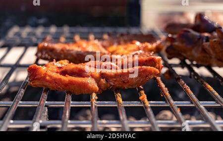 Schweinesteaks kochen über dem Grill. Seitenansicht. Stockfoto