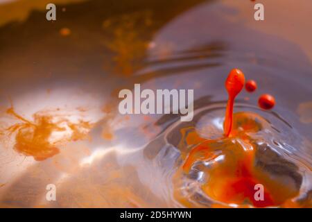 Orange Farbe spritzt in Wasser schaffen viele Farbblasen und Tropfen und andere Effekte. Stockfoto