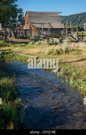 Die alte Holzscheune und die Korrale auf dem John Moulton Gehöft in der Mormon Row im Grand Teton National Park mit der Teton Range dahinter. Wyoming, USA. Stockfoto