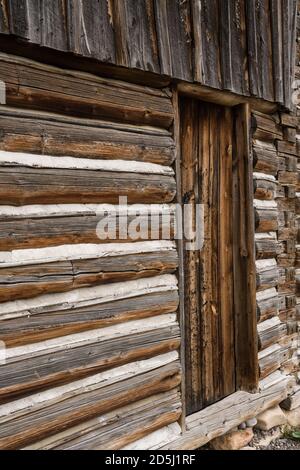 Detail der alten Blockscheune auf dem John Moulton Gehöft auf der Mormon Row im Grand Teton National Park mit den Tetons dahinter. Wyoming, USA. Stockfoto