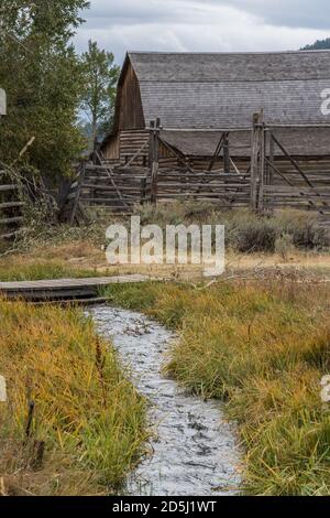 Ein Pionier Bewässerungskanal und Korralen und Scheune des John Molton Gehöfts auf Mormon Row im Grand Teton National Park, Wyoming, USA. Stockfoto