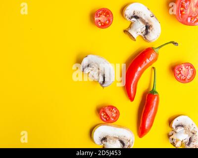 Gesunde Ernährung und Diät-Konzept. Kreatives Layout aus Tomaten, Paprika und Champignon isoliert auf gelber Farbe Studio-Hintergrund mit c Stockfoto