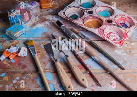 Künstler Schreibtisch und Materialien mockup.Various Bürsten, Pallete Messer und Pallete.The Holzschreibtisch ist mit schönen verschiedenen Farben bedeckt. Stockfoto