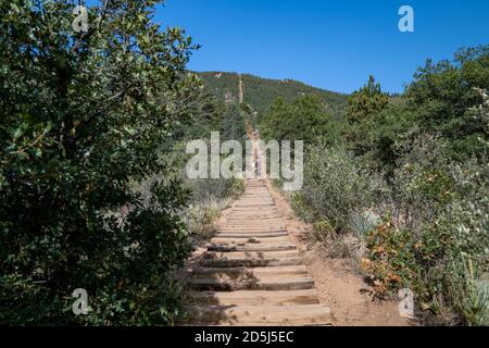 Manitou Springs, Colorado - 15. September 2020: Die alten Eisenbahnschwellen, aus denen die Manitou Incline Wanderung in Colorado besteht. Wanderer weit in der Ferne Stockfoto