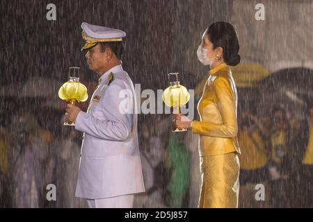 Bangkok, Thailand. Oktober 2020. Thailands Premierminister Prayut Chan-O-Cha und seine Frau Naraporn Chan-o-cha sahen während der vierten Jubiläumsfeier, die den Tod des verstorbenen thailändischen Königs Bhumibol Adulyadej (Rama 9) ansah, Kerzen bei starkem Regen halten. Kredit: SOPA Images Limited/Alamy Live Nachrichten Stockfoto