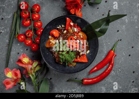 Rinderwak. Traditionelle chinesische mongolische Rindfleisch rühren braten in chinesischen Gusseisen Wok mit Kochstäbchen, Stein Schiefer Hintergrund. Draufsicht, Kopierbereich Stockfoto