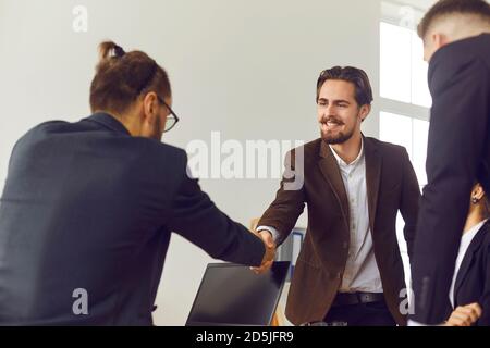 Geschäftsmann schüttelt die Hände mit einem neuen Teammitglied und gratuliert dem Partner zu einem erfolgreichen Abschluss. Stockfoto