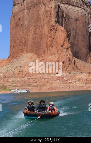 Lake Powell, Arizona, USA. August 2020. Kinder können auf dem Lake Powell Wassersport betreiben, während sie mit dem Schnellboot abgeschleppt werden. Lake Powell ist ein künstlich anmalten Stausee am Colorado River im Glen Canyon National Recreation Area und erstreckt sich über zwei westliche Staaten Utah und Arizona. Es ist ein wichtiger Urlaubsort, der sich vom Beginn des Grand Canyon in Arizona bis in den Süden Utahs erstreckt. Das Glen Canyon National Recreation Area ist mit malerischen Aussichten, einzigartiger Geologie und 10,000 Jahren menschlicher Geschichte geschmückt. Zu den Aktivitäten gehören Bootfahren, Angeln, Wandern. Lake Powell, ist der zweitgrößte Mensch gemacht See in den Vereinigten Staaten Stockfoto