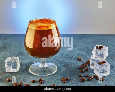 Kaltgetränk oder Nitro Kaffeetrink in einem Glas mit Schaum, Eis und Kaffeebohnen. Stockfoto