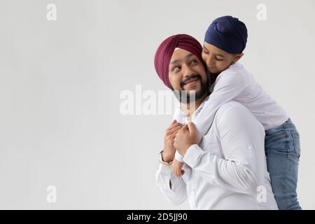 EIN SIKH VATER SOHN DUO GENIESSEN FREIZEIT GLÜCKLICH UND EINANDER ANSCHAUEND Stockfoto