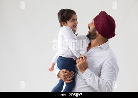 EINE SIKH-TOCHTER UND EIN VATER SCHAUEND SICH GEGENSEITIG AN UND GEMEINSAM GENIESSEN Stockfoto