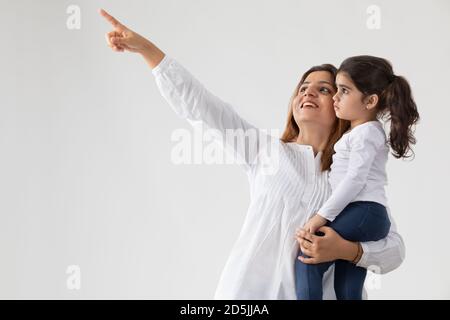 EINE MUTTER LÄCHELT UND ZEIGT IHRER TOCHTER ETWAS Stockfoto