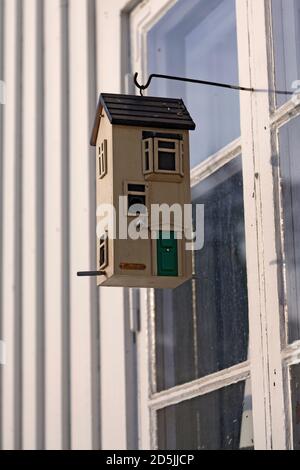 Modernes Vogelhaus, das vor den Fenstern hängt Stockfoto