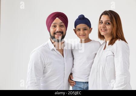 EINE SIKH FAMILIE LÄCHELT UND POSIERT Stockfoto