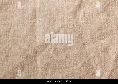 Beigefarbene Tischdecke aus Textil-Leinen im Vollformat. Hintergrund mit Stofftextur. Speicherplatz kopieren. Stockfoto