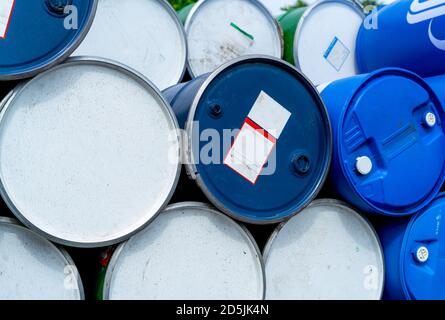 Stapel alter chemischer Fässer. Blaue Ölfass. Öltank aus Stahl und Kunststoff. Lager für giftige Abfälle. Gefährliche Chemikalienfass. Industrieabfälle in Kunststoff. Stockfoto