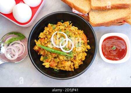 Indisches Frühstücksgericht: Parsi Akuri oder Anda Bhurji oder indische, würzige Rühreier, serviert mit geröstetem braunem Brot und Ketchup. Berühmte indische Street Food Stockfoto