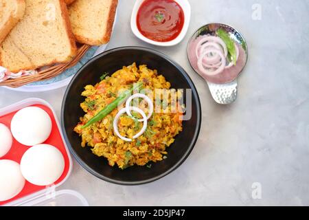 Indisches Frühstücksgericht: Parsi Akuri oder Anda Bhurji oder indische, würzige Rühreier, serviert mit geröstetem braunem Brot und Ketchup. Berühmte indische Street Food Stockfoto