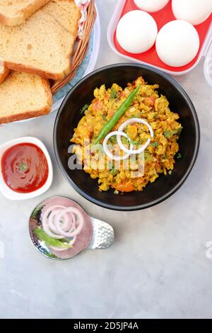 Indisches Frühstücksgericht: Parsi Akuri oder Anda Bhurji oder indische, würzige Rühreier, serviert mit geröstetem braunem Brot und Ketchup. Berühmte indische Street Food Stockfoto