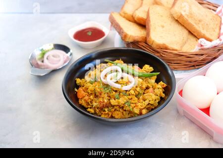 Indisches Frühstücksgericht: Parsi Akuri oder Anda Bhurji oder indische, würzige Rühreier, serviert mit geröstetem braunem Brot und Ketchup. Berühmte indische Street Food Stockfoto