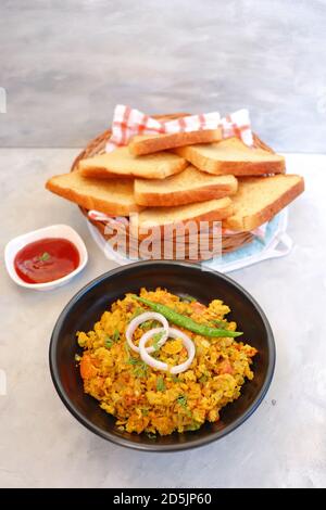 Indisches Frühstücksgericht: Parsi Akuri oder Anda Bhurji oder indische, würzige Rühreier, serviert mit geröstetem braunem Brot und Ketchup. Berühmte indische Street Food Stockfoto