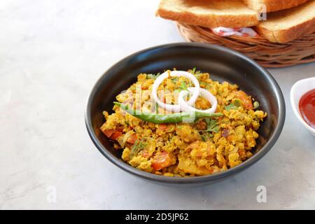 Indisches Frühstücksgericht: Parsi Akuri oder Anda Bhurji oder indische, würzige Rühreier, serviert mit geröstetem braunem Brot und Ketchup. Berühmte indische Street Food Stockfoto