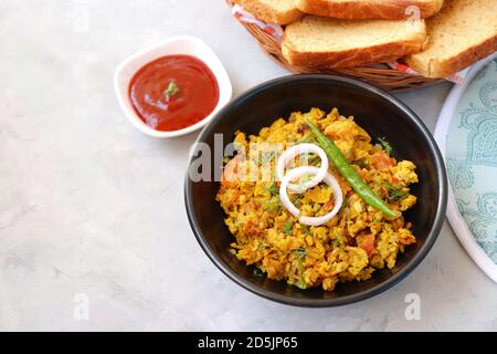 Indisches Frühstücksgericht: Parsi Akuri oder Anda Bhurji oder indische, würzige Rühreier, serviert mit geröstetem braunem Brot und Ketchup. Berühmte indische Street Food Stockfoto