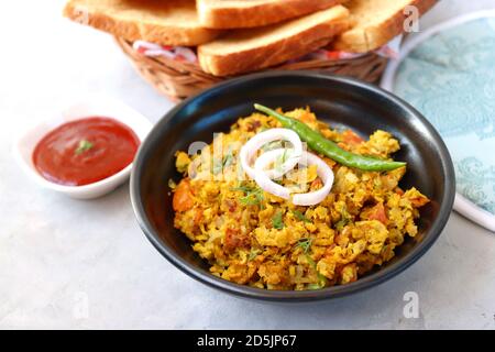 Indisches Frühstücksgericht: Parsi Akuri oder Anda Bhurji oder indische, würzige Rühreier, serviert mit geröstetem braunem Brot und Ketchup. Berühmte indische Street Food Stockfoto