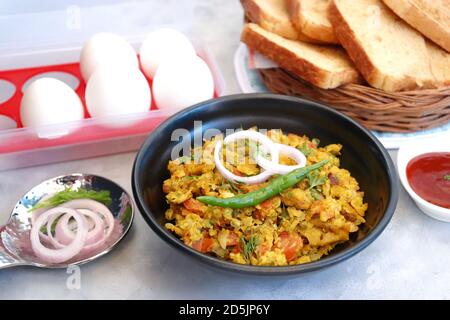 Indisches Frühstücksgericht: Parsi Akuri oder Anda Bhurji oder indische, würzige Rühreier, serviert mit geröstetem braunem Brot und Ketchup. Berühmte indische Street Food Stockfoto