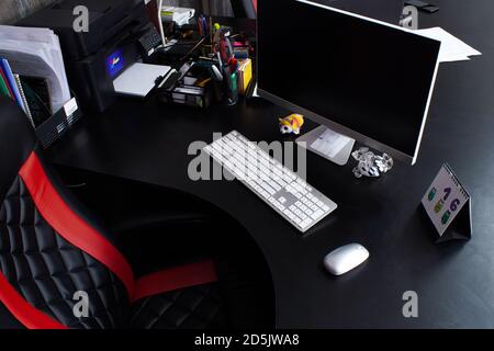 Arbeitsplatz am Tisch im Büro mit Computer, weißer Maus, Tastatur, Monitor und großem Lederstuhl. Persönlicher Raum für die Arbeit. Dokumente, Kalend Stockfoto