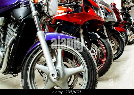 Schöne Gruppe Parkplatz von Motorrädern in einem Showroom zum Verkauf, in einem Geschäft close-up. Wartung von Sportbikes, Rennrädern in der Werkstatt. Moto-Teile, Stockfoto