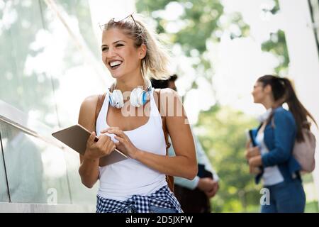 Eine Gruppe glücklicher Studenten, die zusammen studieren und im Freien Spaß haben Stockfoto