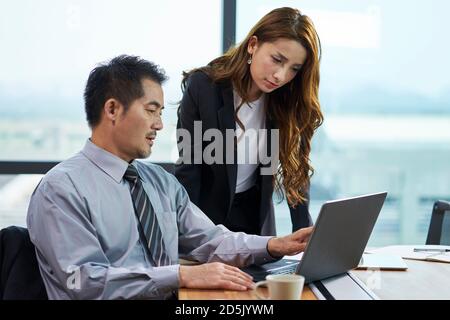 asiatische Geschäftsmann und Geschäftsfrau mit einer Diskussion im Büro mit Laptop-Computer Stockfoto