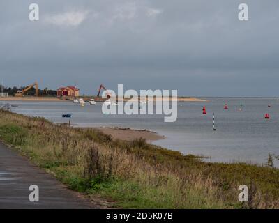 Blick vom Strand Gehen Sie an einem langweiligen Tag auf die Big Gap hinaus und zeigen Sie die alte Rettungsbootstation und Bagger am Hafen von Wells Next the Sea, Norfolk, Großbritannien. Stockfoto