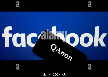 QAnon im Vergleich ZU FACEBOOK. QAnon-Unternehmenslogo auf dem Smartphone, das auf Facebook-Logos platziert ist. Konzept für das Verbot von QAnon in sozialen Medien. Stockfoto