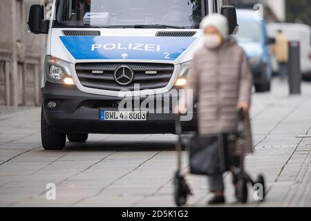 Stuttgart, Deutschland. Oktober 2020. Eine Frau mit Mund- und Nasenschutz geht mit Hilfe eines Rollators an einem Polizeiwagen in der Königstraße vorbei. In der Landeshauptstadt treten strengere Coronaregeln in Kraft. Unter anderem besteht im City Ring eine Verpflichtung zum Mund- und Nasenschutz. Quelle: Sebastian Gollnow/dpa/Alamy Live News Stockfoto