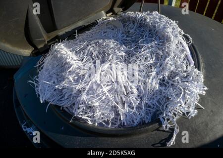 Recyclingbehälter voll mit geschreddertem Papier Stockfoto