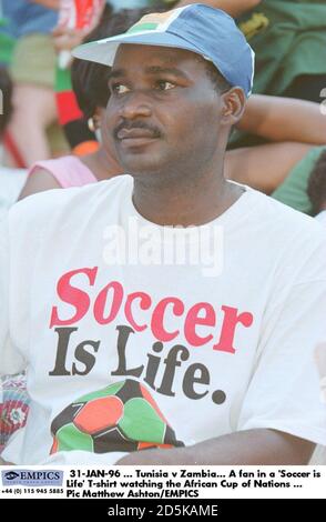 31-JAN-96 ... Tunesien – Sambia. Ein Fan in einem „Soccer is Life“ T-Shirt, der den Afrikanischen Cup der Nationen beobachtet Stockfoto