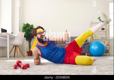 Fröhlicher bärtiger Mann in farbenfroher Sportswear, der Sport-Workout macht Zu Hause Stockfoto