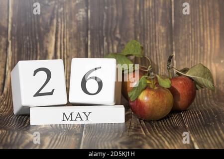 Mai 26. Tag 26 des Monats. Kalenderwürfel auf Holzhintergrund mit roten Äpfeln, Geschäftskonzept und einem wichtigen Ereignis. Frühjahrssaison. Stockfoto