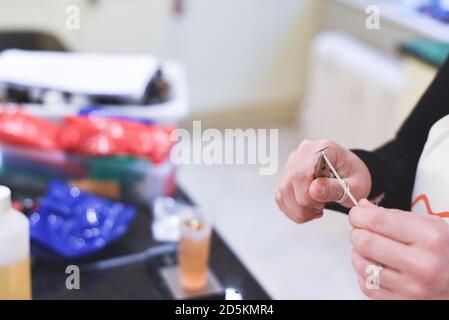 Ein Chandler oder Kerzenmacher fügt einen Docht zu duftenden Handgemachte Kerzen Stockfoto