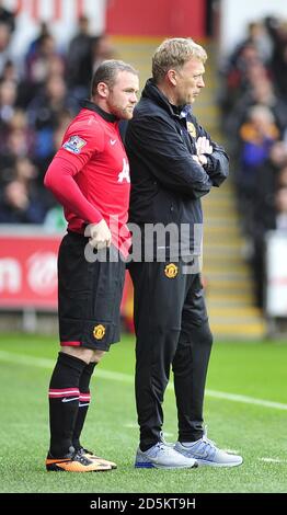 Manchester United Manager David Moyes spricht mit Wayne Rooney, bevor er aufkommt. Stockfoto