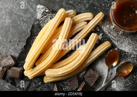 Konzept des Mittagessens mit Churros und Schokolade auf dunklem Tisch Stockfoto