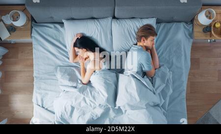 Streitereien Junges Paar im Bett, Junge Leute liegen sich von einander abgewandt und lagen auf ihren Seiten mit Groll und beleidigt Stockfoto